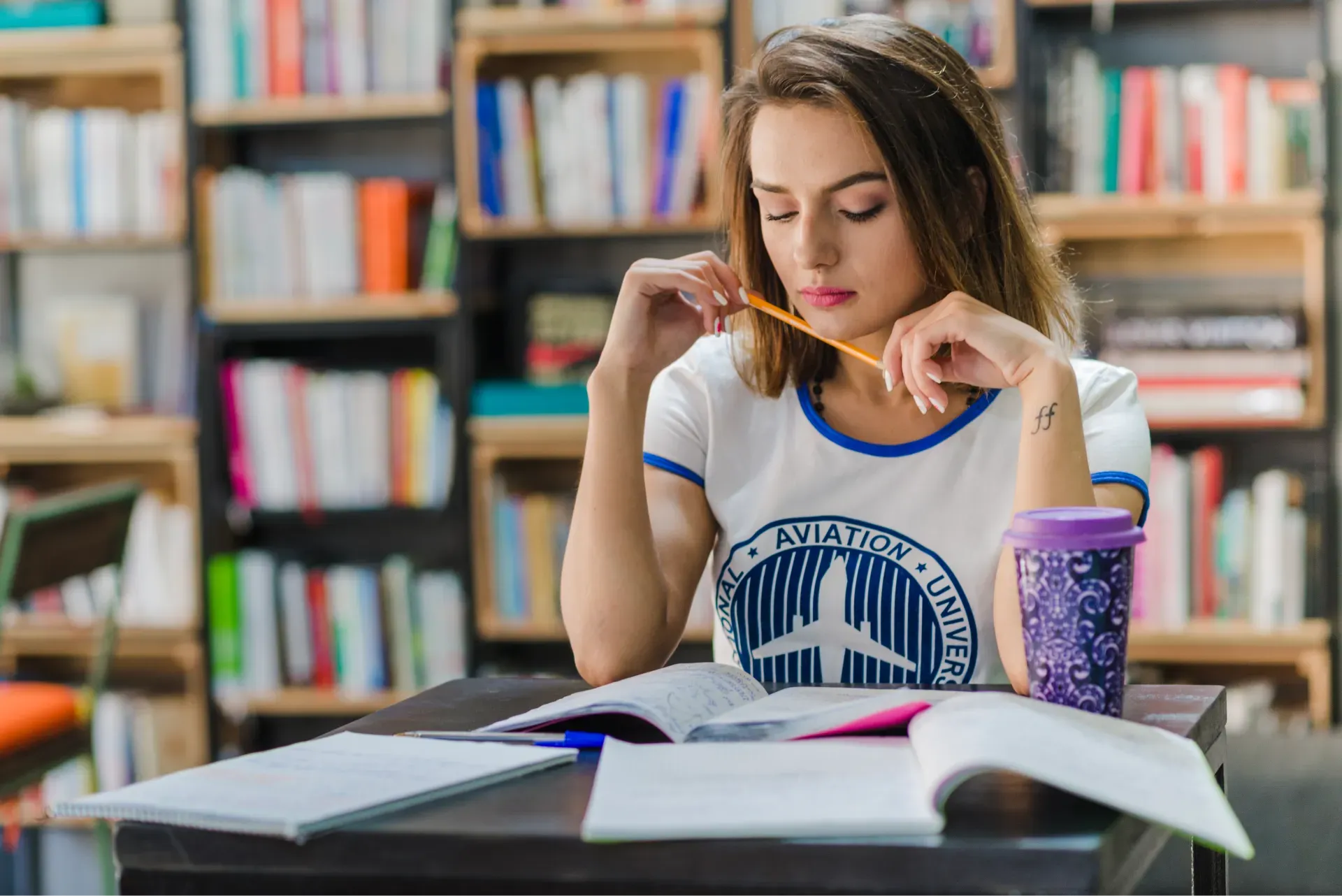 girl_sitting_table_with_notebooks.webp