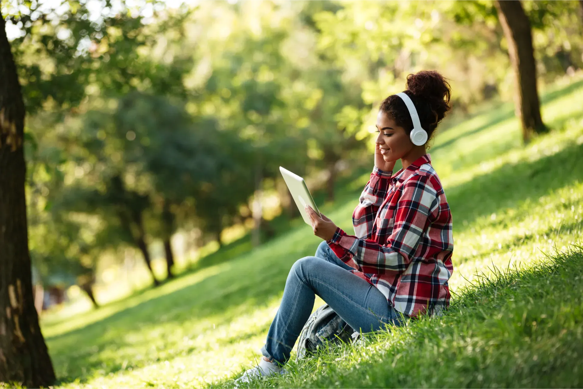 happy_young_african_woman_sitting_outdoors_park.webp
